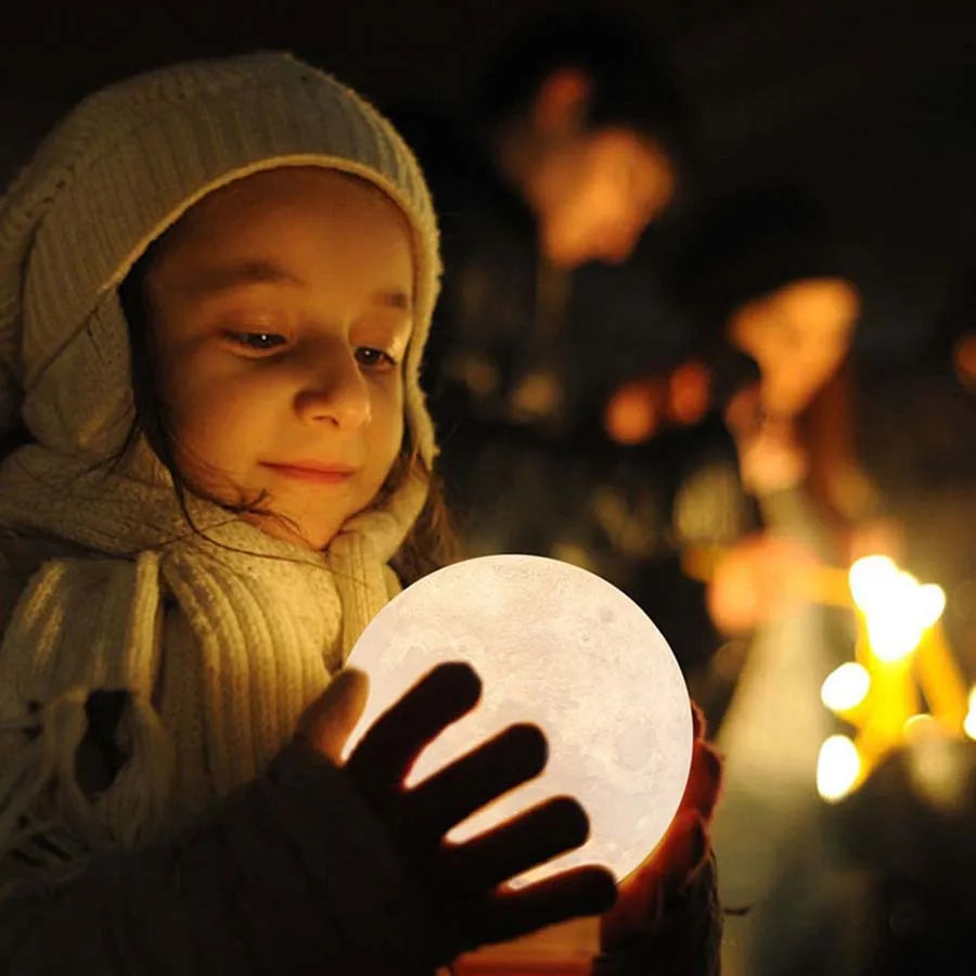 Enfant tenant une lampe lune allumée